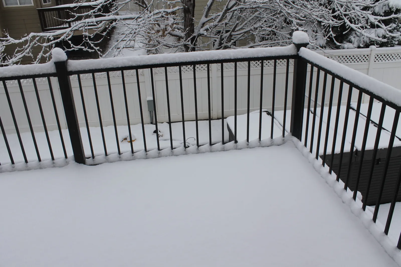 Snow covered deck railing in Colorado showing winter deck care and freeze thaw conditions